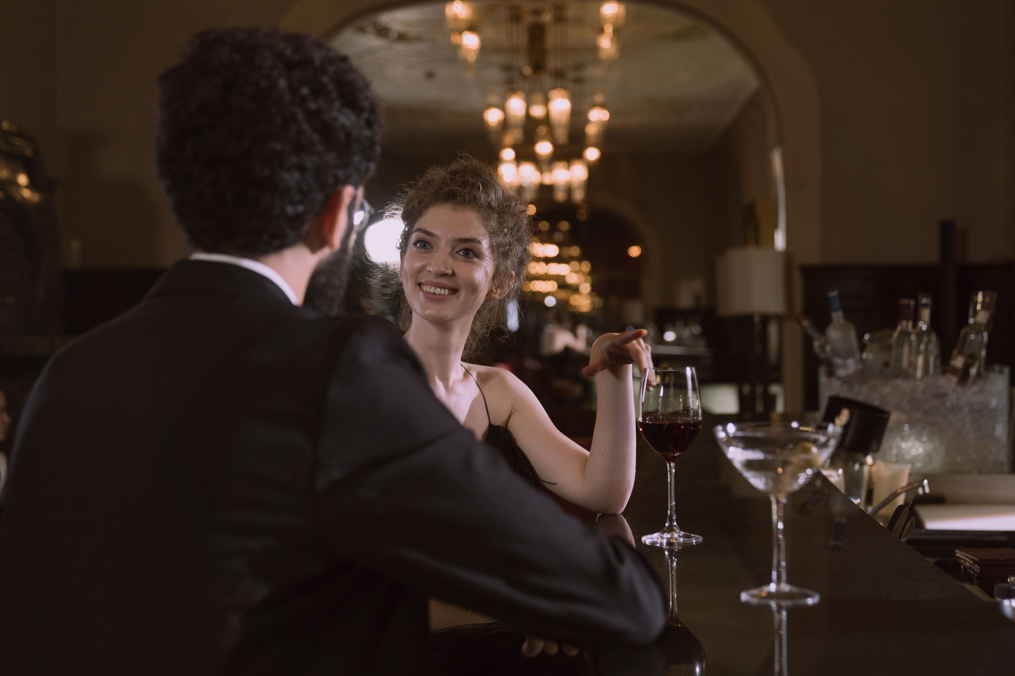 Sophisticated couple sharing cocktails at a dimly lit upscale bar