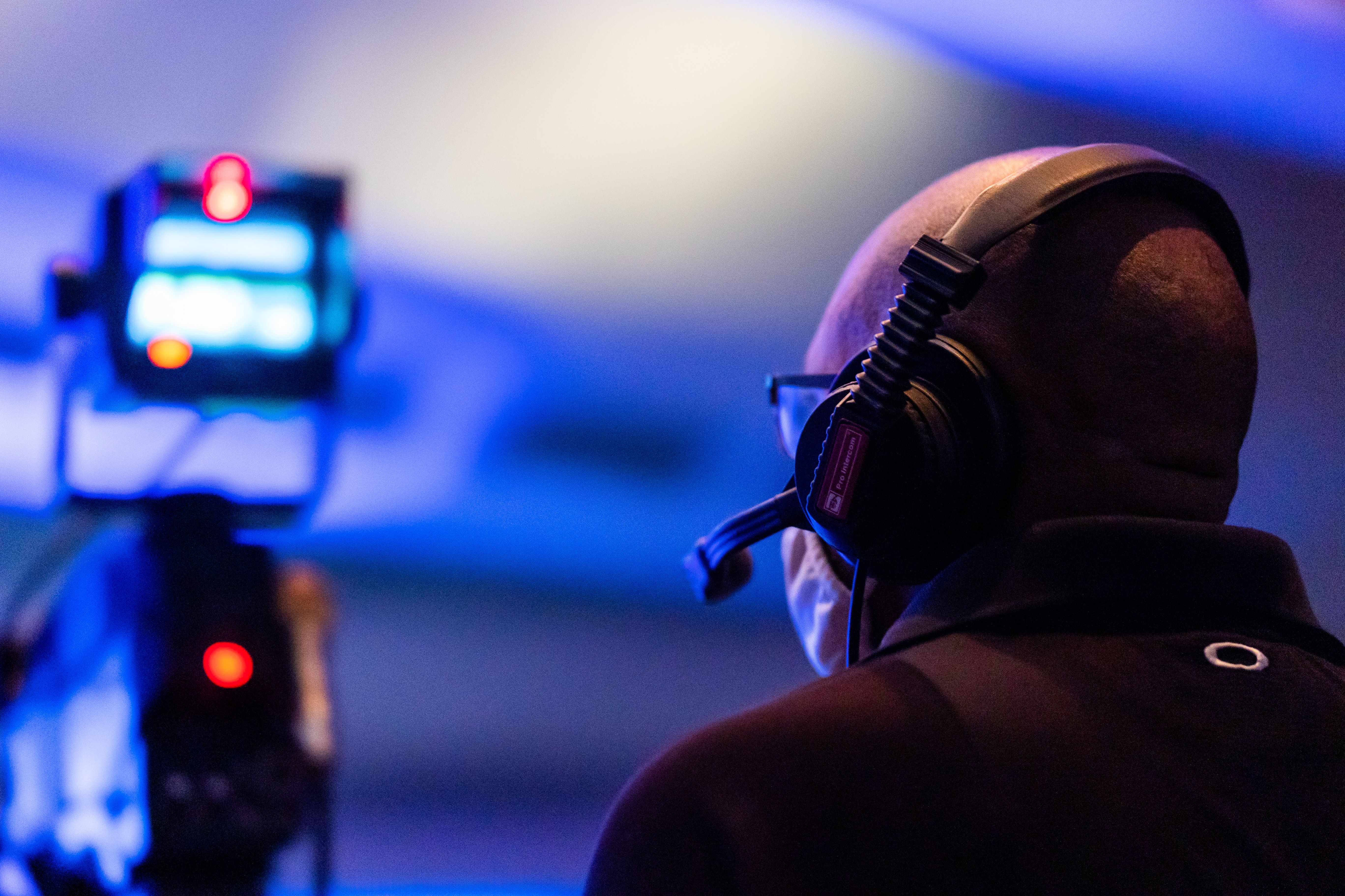 A man with a headset overseeing a live event in a dimly lit environment