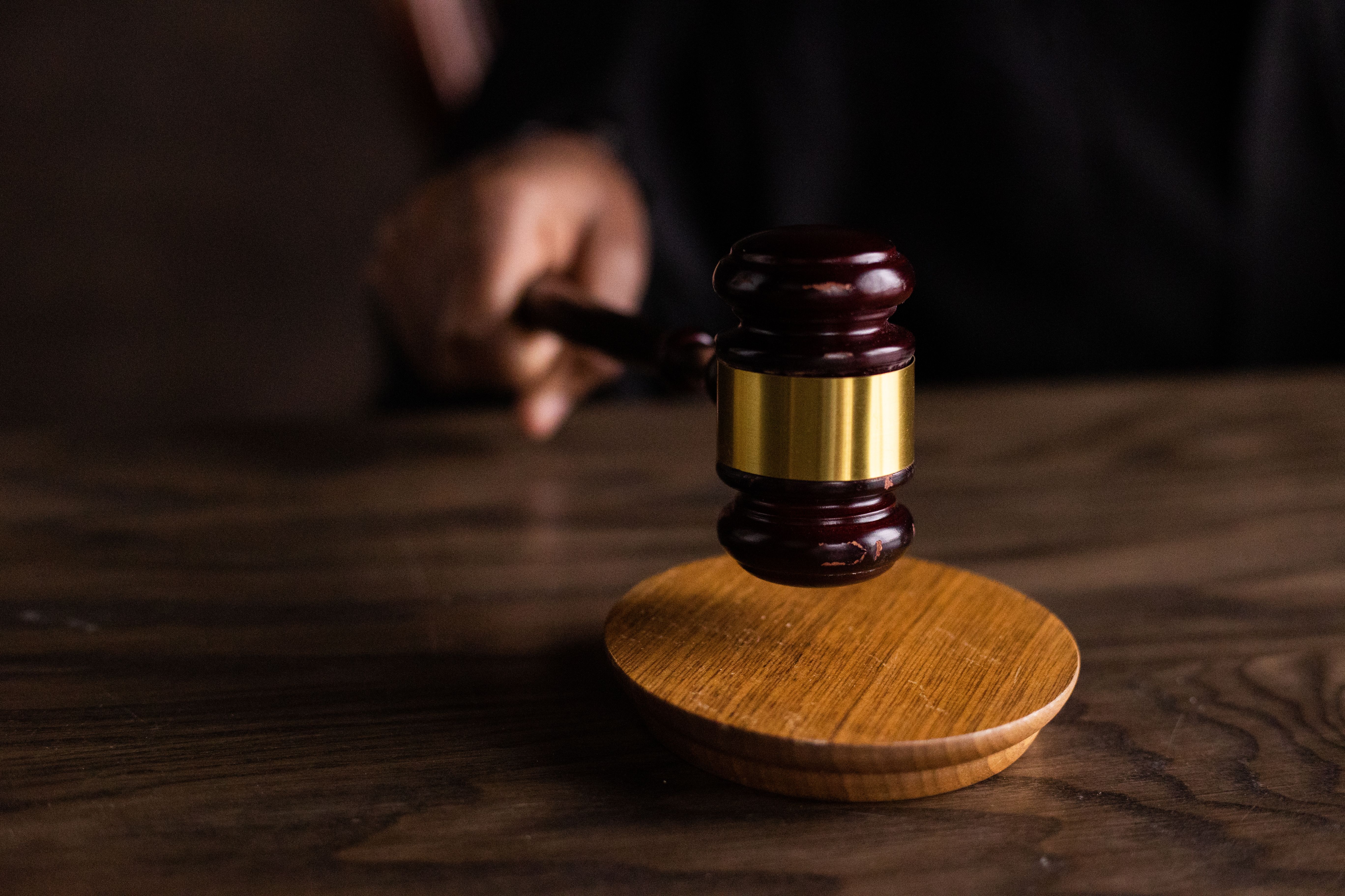 Judge's gavel striking a sound block in a courtroom representing litigation