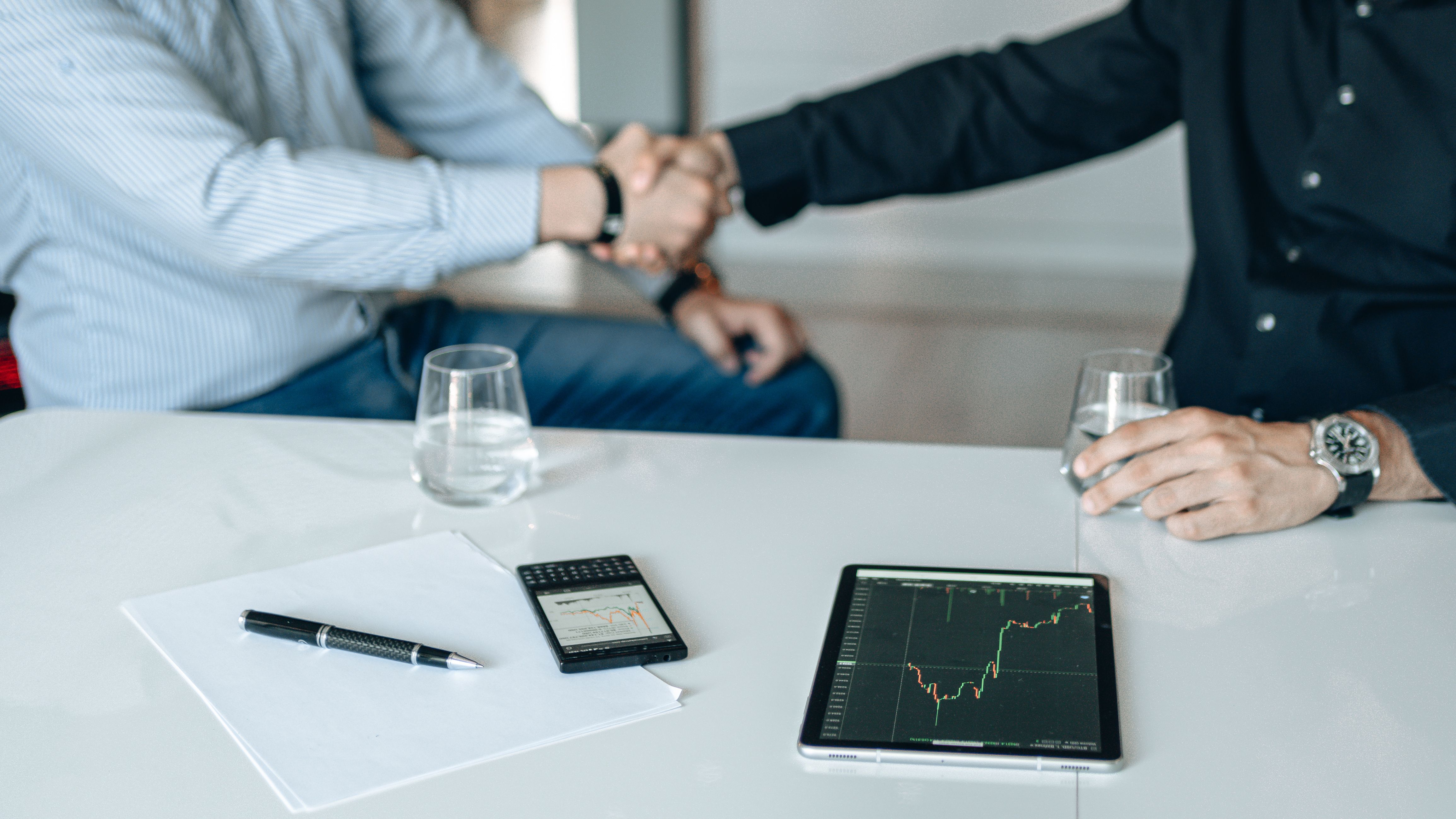 Business handshake over financial analysis representing litigation investment funding