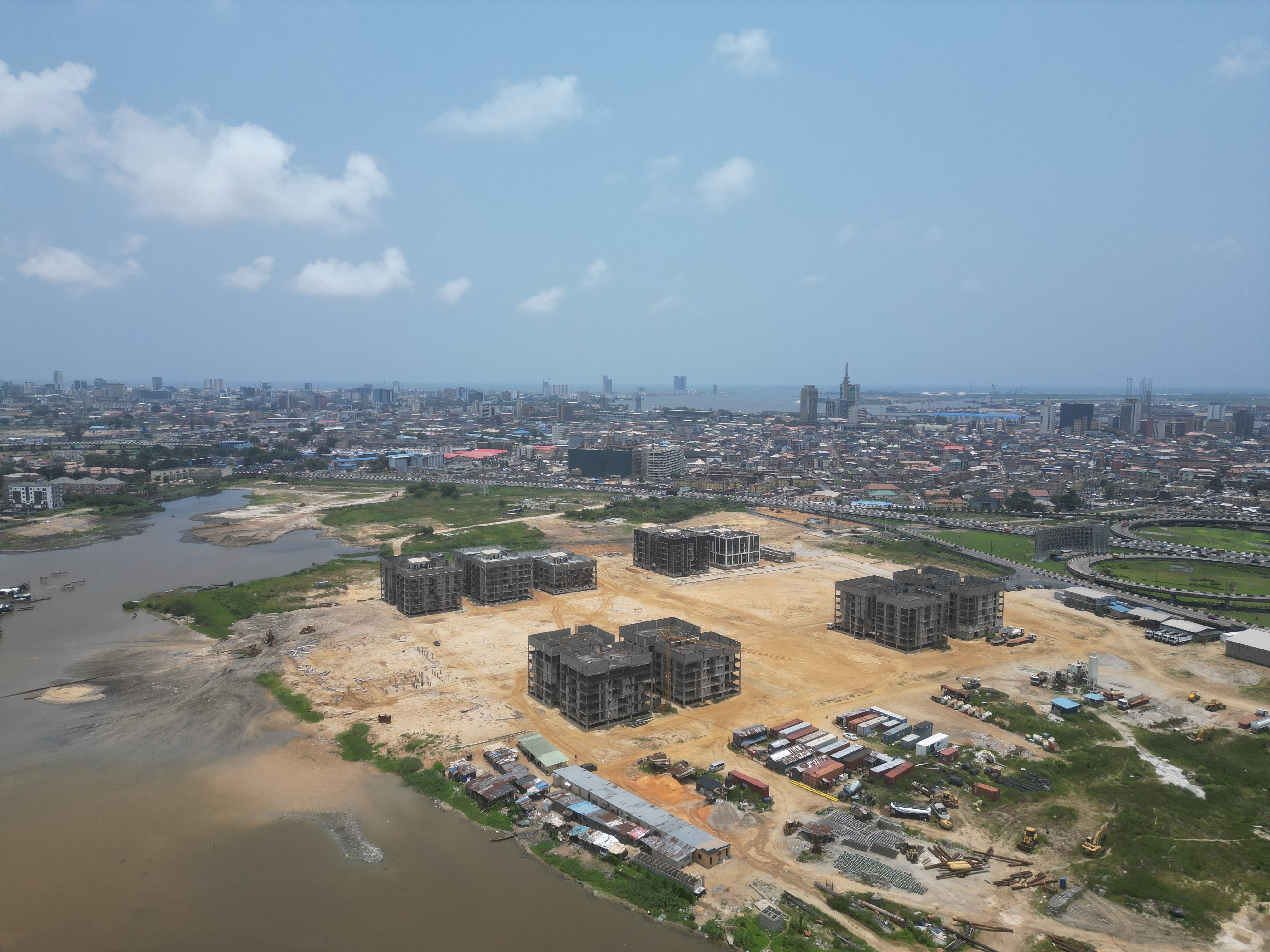 Aerial view of a construction site beside a city skyline, showing infrastructure investment and regional growth.